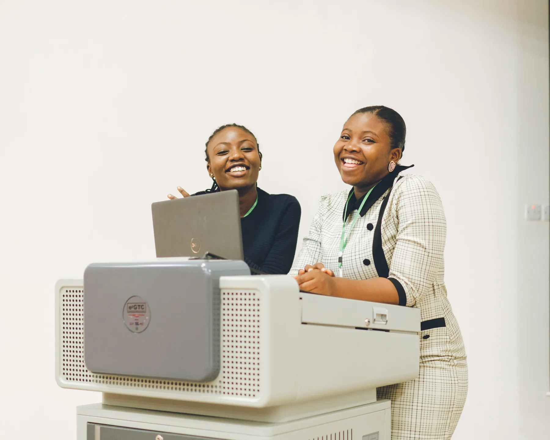 Two presenters smiling behind a conference lectern